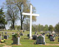 There is a big size white cross in the cemetery.
